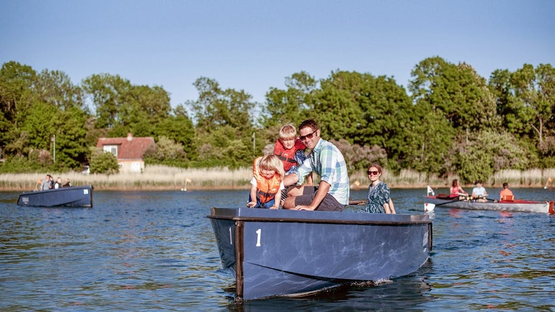 Family enjoying a boat tour in Copenhagen harbor with city views and landmarks.