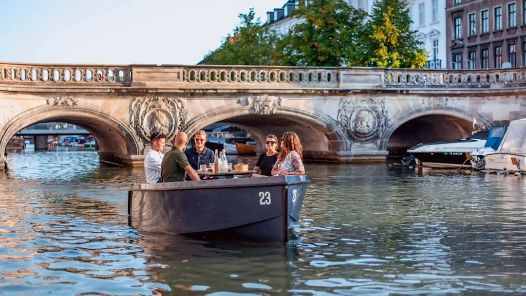 Friends on a GoBoat tour under a bridge in Copenhagen Harbour.