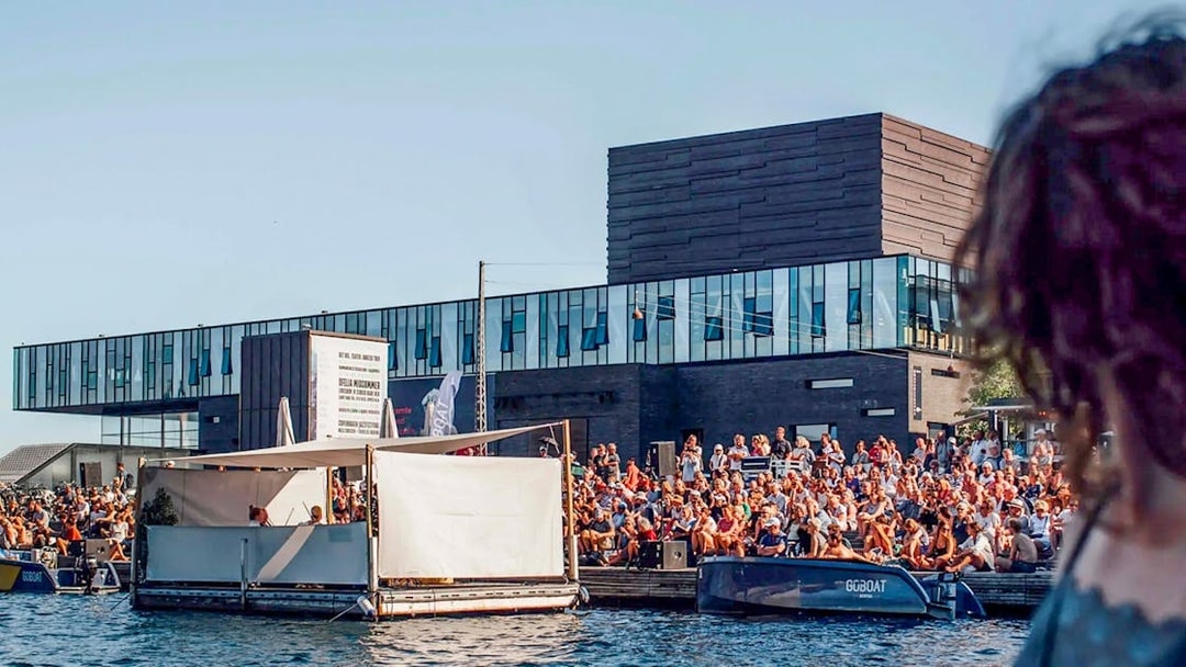 Crowd gathered by the water near The Playhouse in Copenhagen.