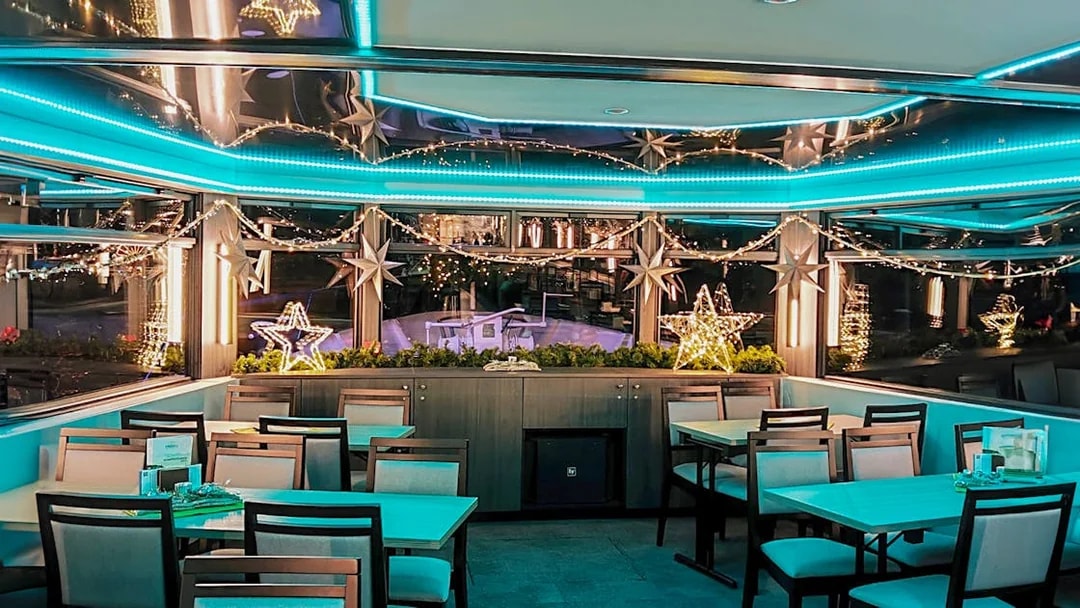 Festive dining area with star lights on a Cologne Advent tour boat.