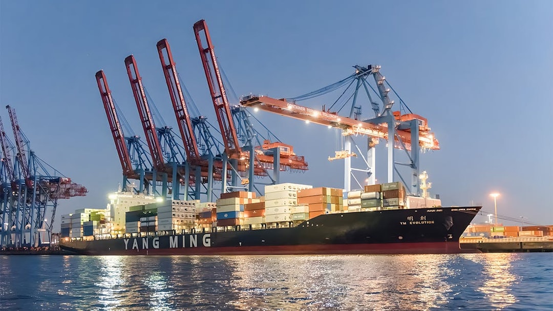 Container ship docked at Grand Harbor under evening lights during 1.5h cruise.