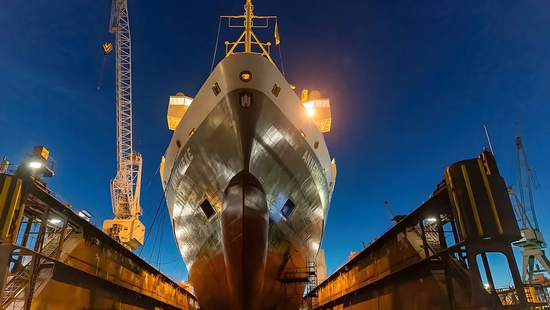Cruise ship docked at Grand Harbor under evening lights.