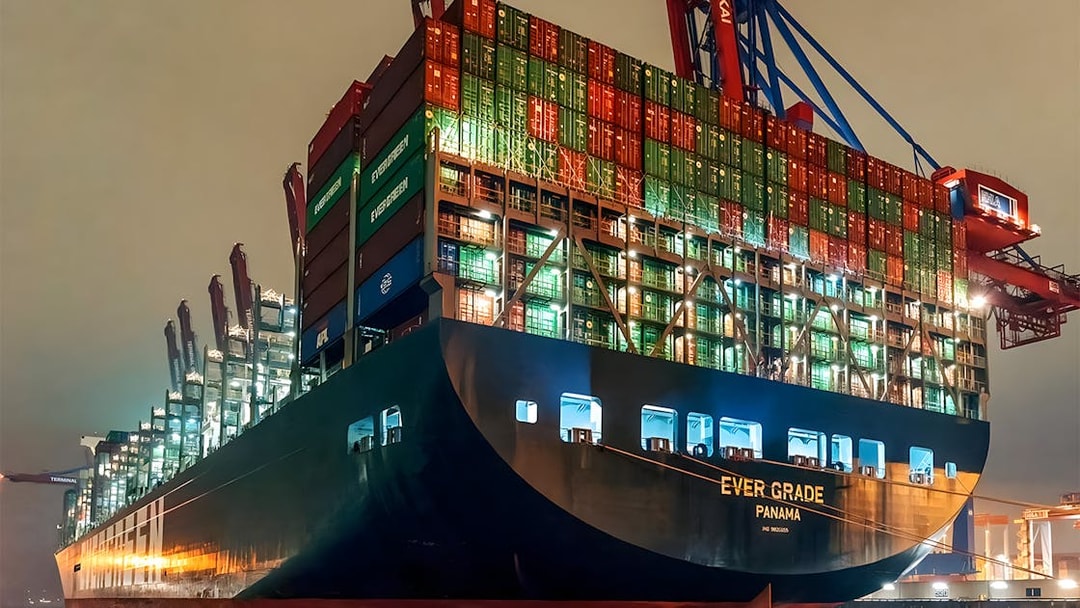 Cargo ship illuminated at night in Grand Harbor during evening lights cruise.
