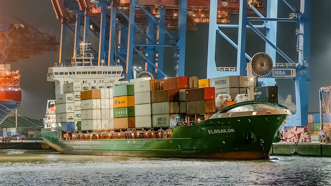 Cargo ship docked at night in Grand Harbor during evening lights cruise.