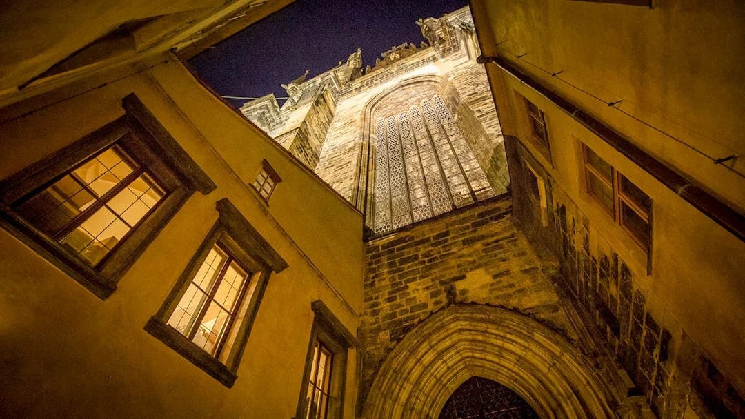 Gothic architecture in Prague's Old Town at night, viewed from a narrow alley.