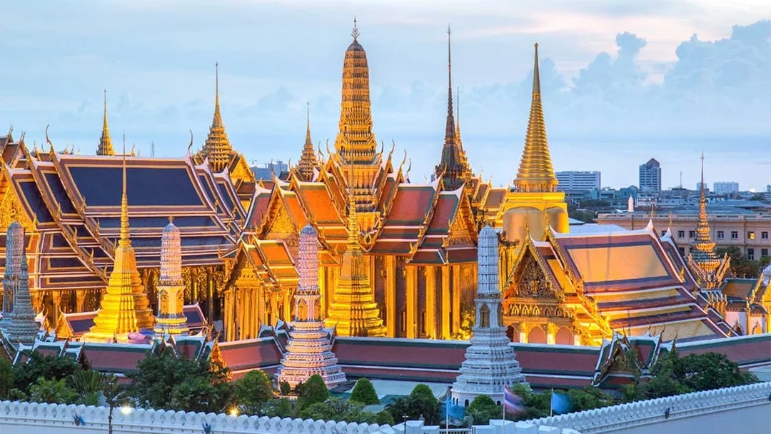 Grand Palace in Bangkok illuminated at dusk, part of 1-day guided temple tour.