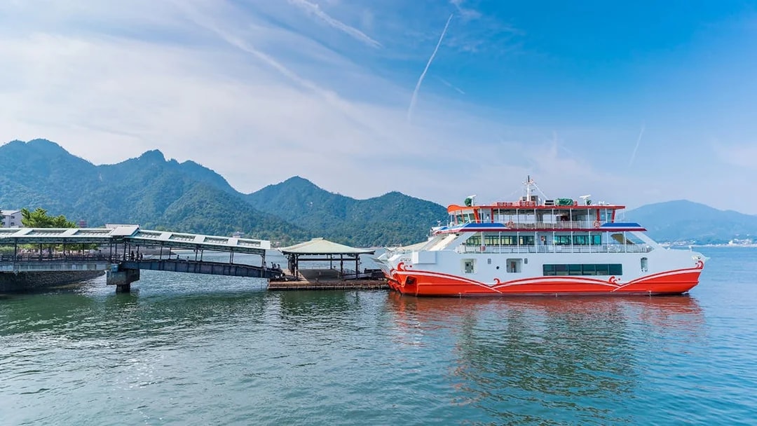 Ferry docked at Miyajima Island with mountains in the background, part of Hiroshima tour.