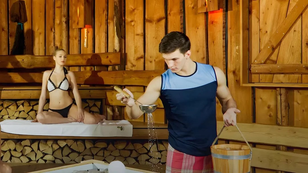 Man pouring water on sauna stones at Bavaria Sauna, Therme Bucuresti.