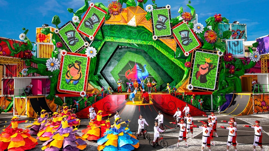 Colorful parade with dancers and performers in vibrant costumes at Disneyland Paris.