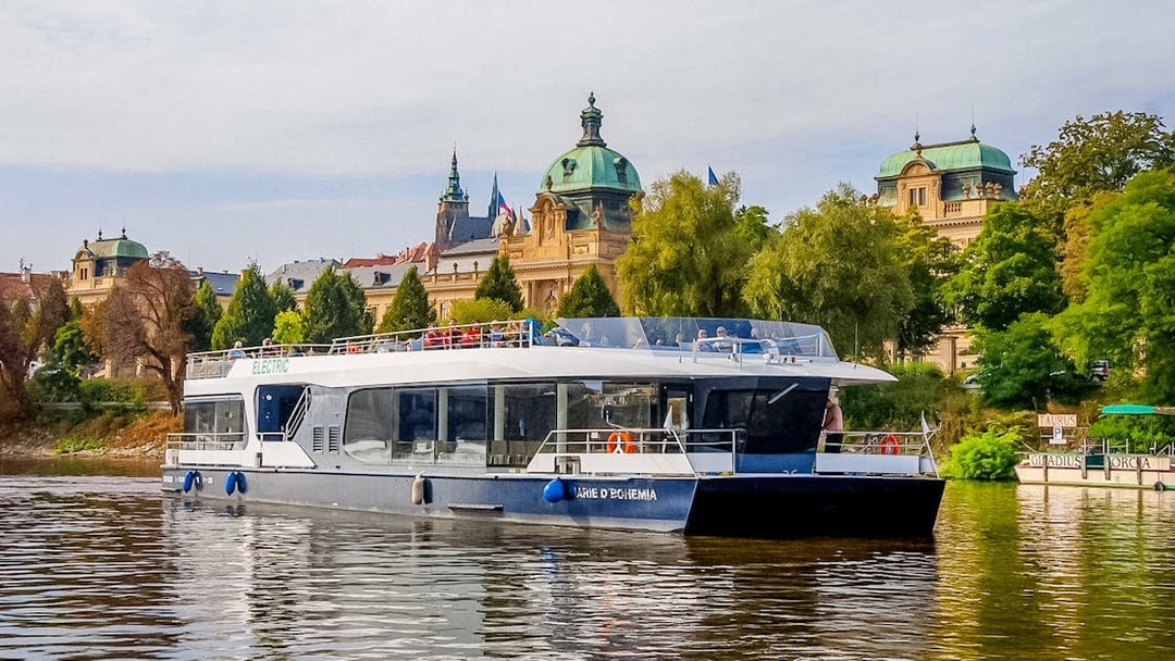 Sightseeing boat on Vltava River with historic Prague architecture in the background.