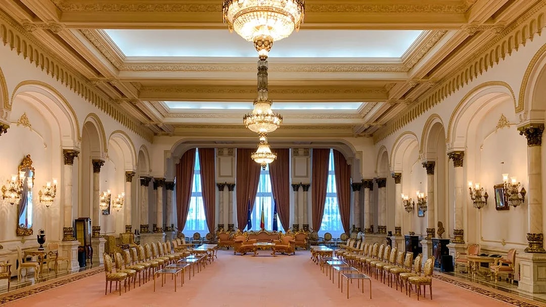 Grand hall with chandeliers and ornate decor inside Palace of Parliament, Bucharest.