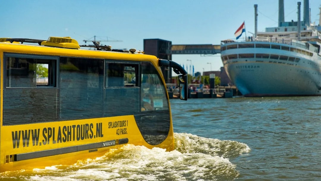 Yellow amphibious bus on Rotterdam waterway during 1-hour sightseeing splash tour.