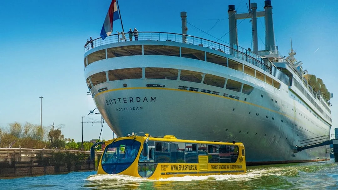 Amphibious bus touring near a large ship in Rotterdam during a 1-hour sightseeing splash tour.
