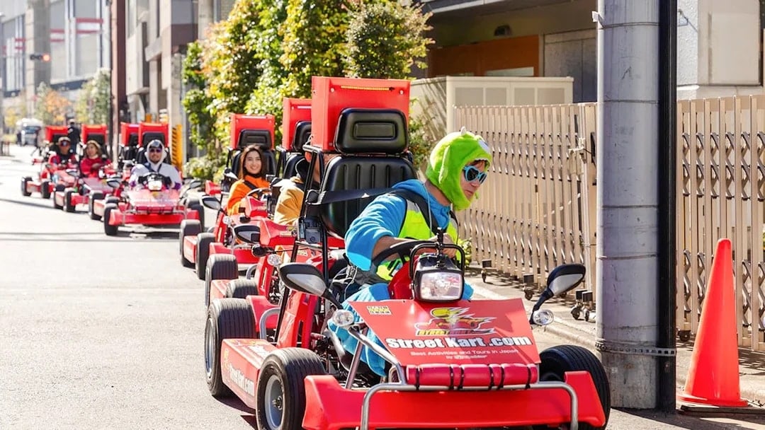 Tourists in costumes driving go karts during Shibuya Go Karting experience in Tokyo.