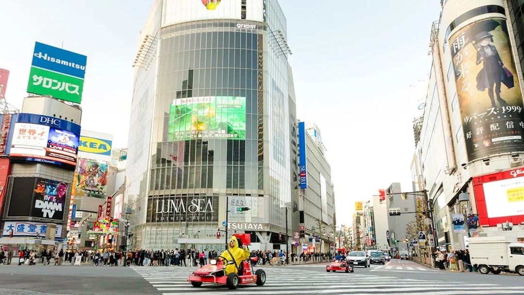 Tourists in go karts driving through Shibuya Crossing during Tokyo go karting experience.