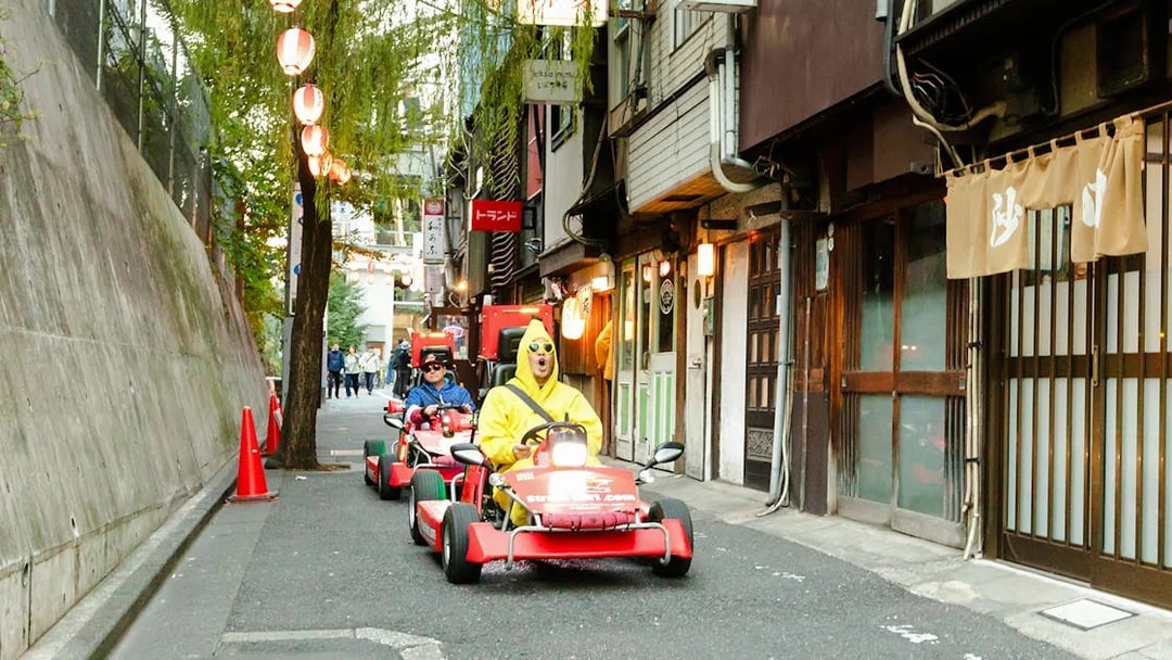 Tourists in go karts driving through Shibuya streets during Tokyo go karting experience.