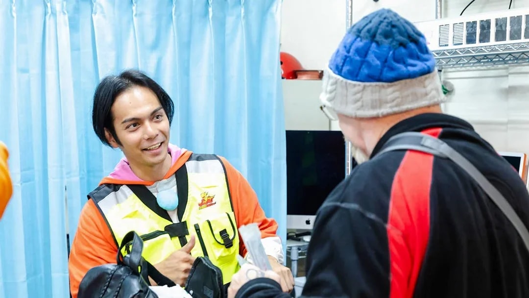 Staff member assists guest at Shibuya Go Karting experience in Tokyo.