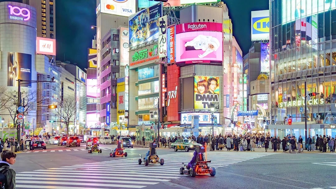Go-karting at night in Shibuya, Tokyo, with illuminated cityscape and bustling streets.
