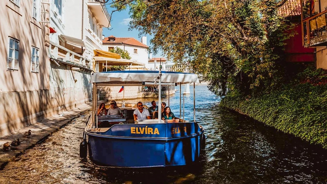 Sightseeing cruise boat on Devils Channel in Prague with passengers.