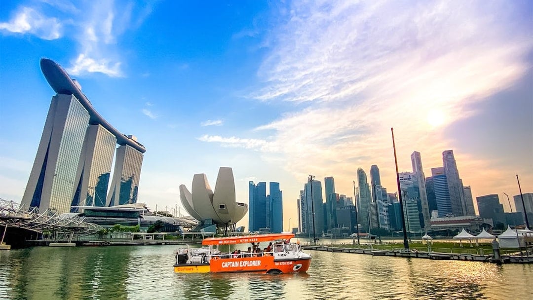 DUKW tour boat on Marina Bay with Singapore skyline and Marina Bay Sands.