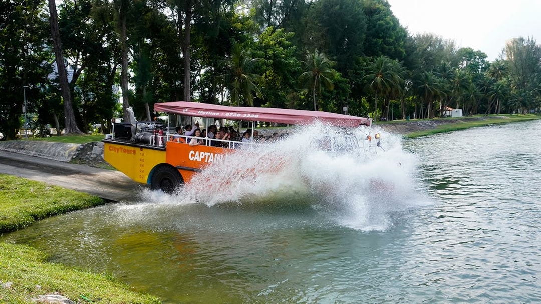 Amphibious vehicle splashing into water during Captain Explorer DUKW Tour in Singapore.
