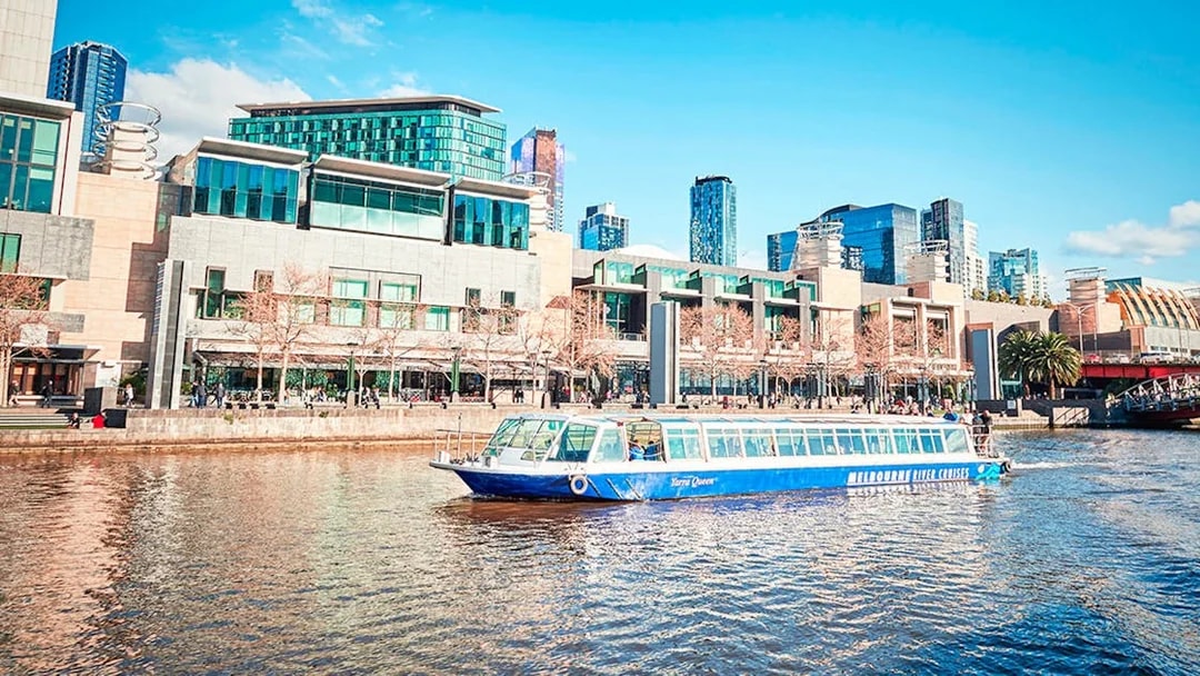 Cruise boat on Melbourne river with city skyline in the background.