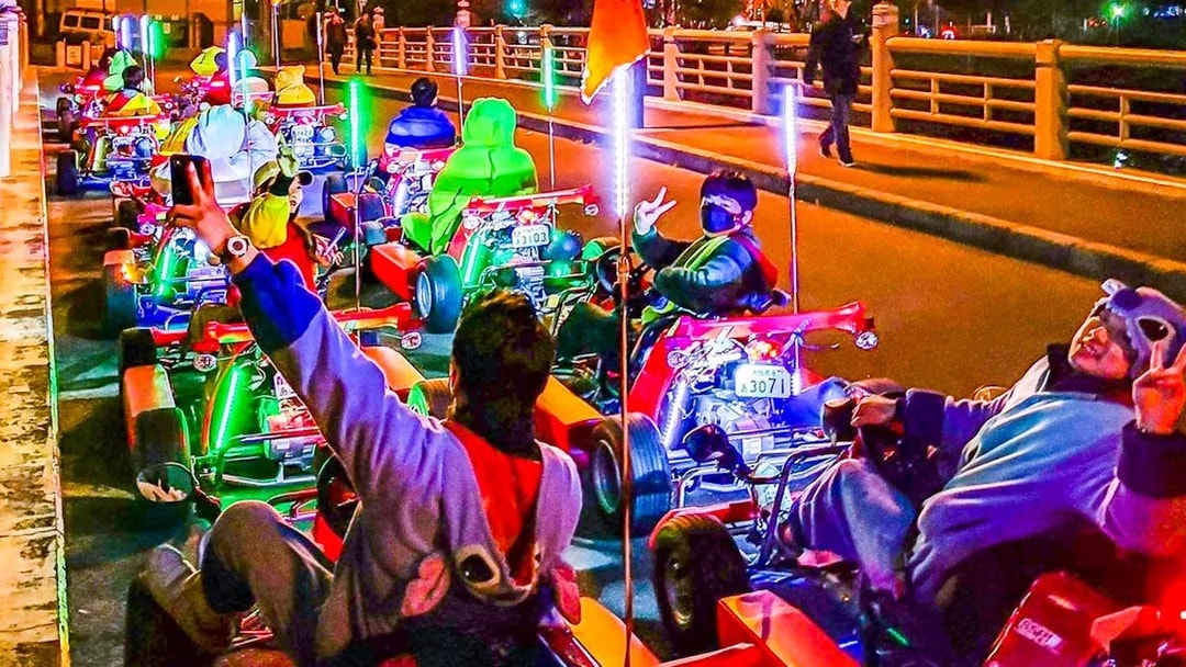 Go-kart riders in costumes on Osaka street during Akiba Kart experience.