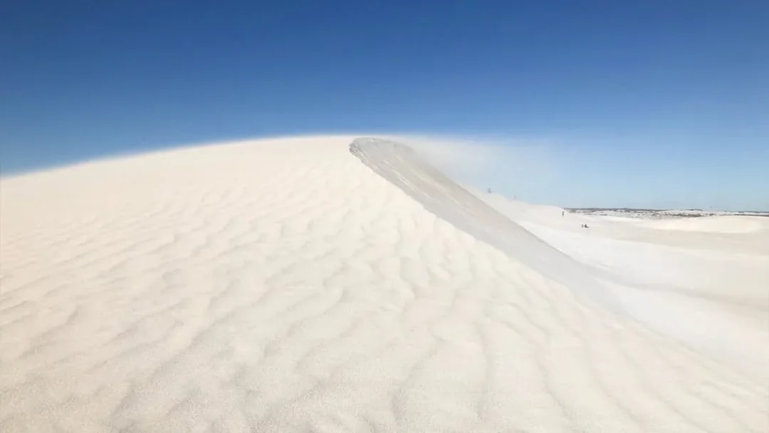 Sand dunes at Australia's Pinnacles under clear blue sky.