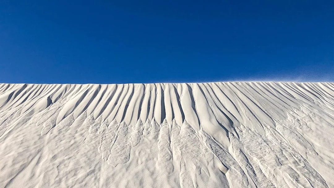 Sand dunes under a clear blue sky on Australia's Pinnacles tour.