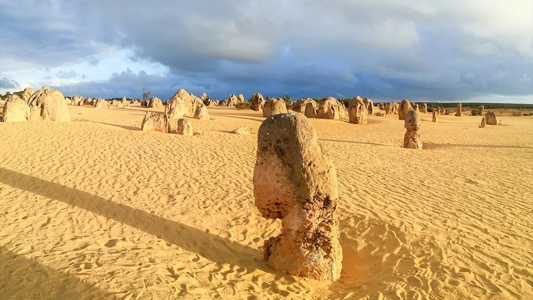 Pinnacles Desert limestone formations under a cloudy sky in Nambung National Park, Australia.
