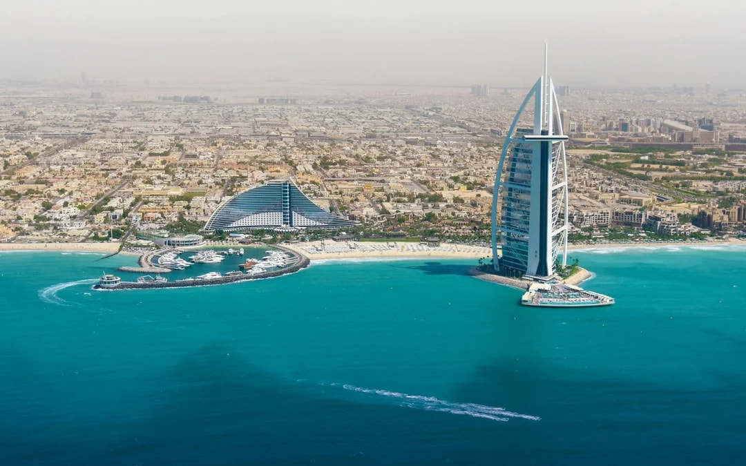 Dubai skyline with Burj Al Arab and coastline from helicopter view.