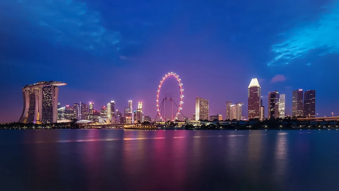 Singapore skyline at night featuring the illuminated Singapore Flyer.
