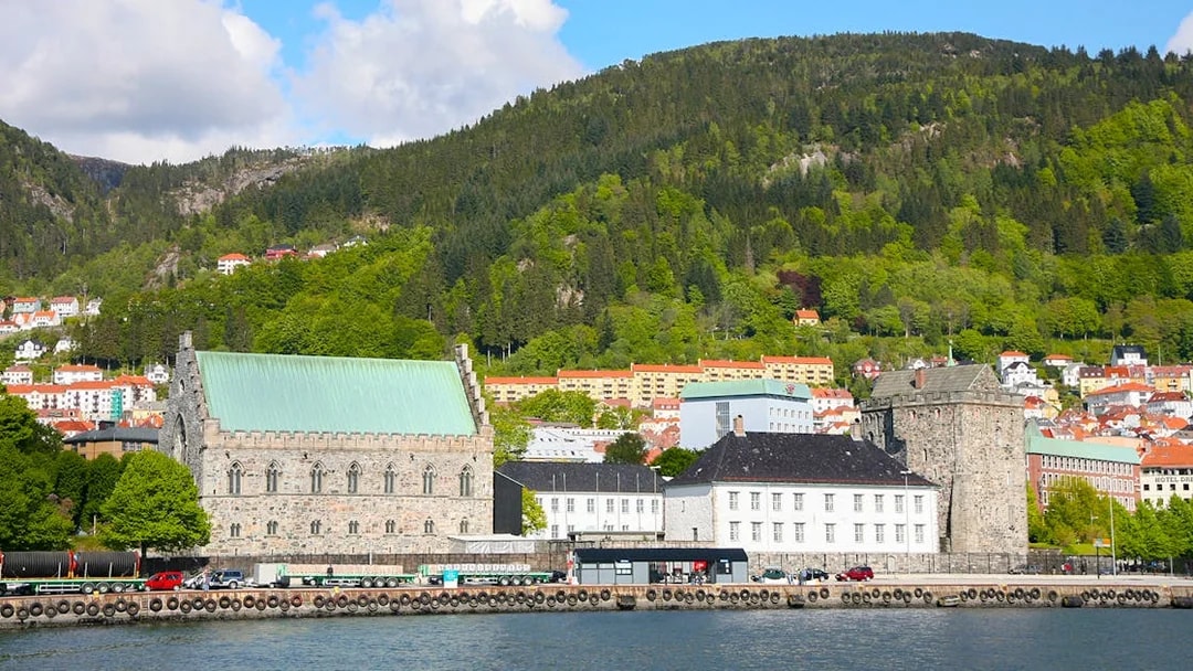 Bergen waterfront with historic buildings and green hills in the background.