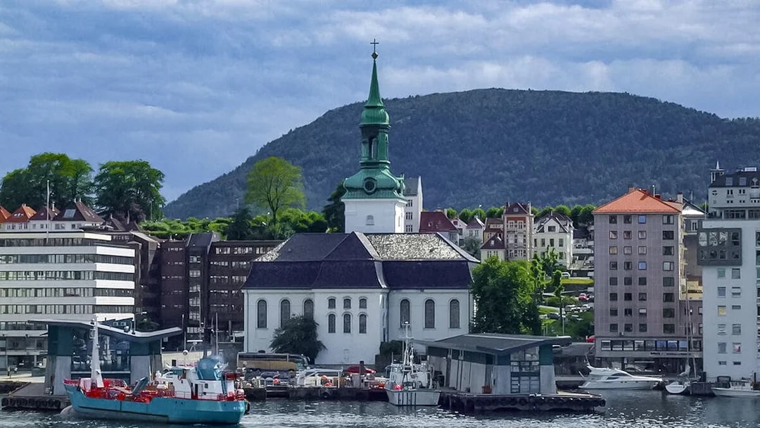 Bergen waterfront with historic church and buildings during sightseeing cruise.