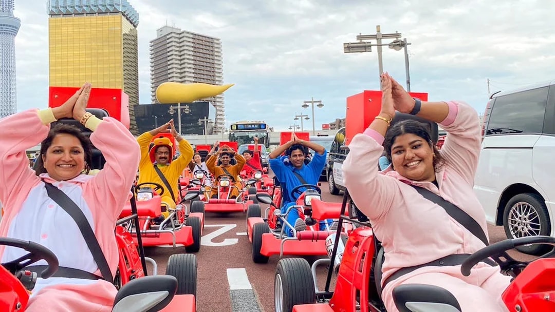 Participants in costumes driving go-karts on Osaka Namba street during 1-hour tour.