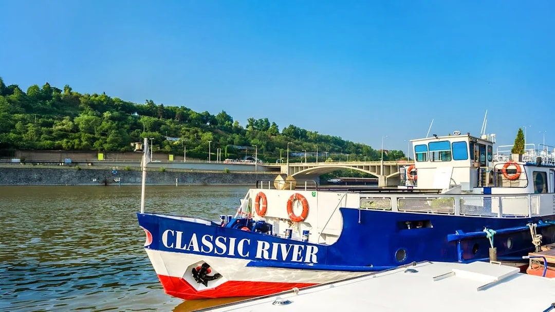 River cruise boat docked near a bridge, ready for an evening dinner cruise with live music.