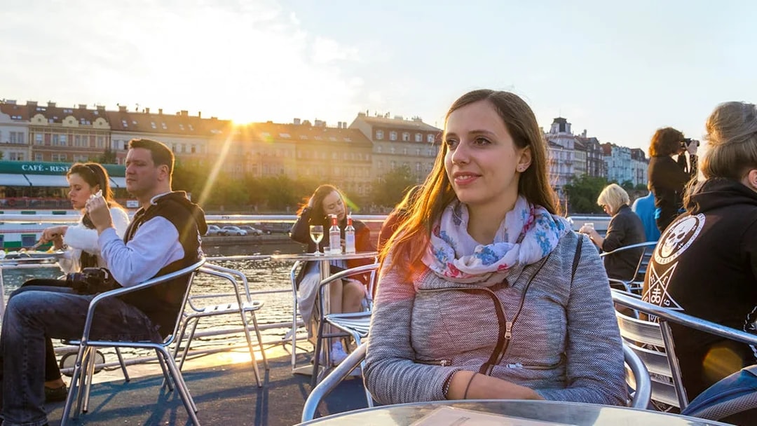 People enjoying a sunset cruise on the Vltava River in Prague.