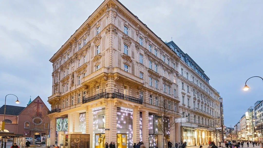 Swarovski House in Vienna with illuminated storefront on a busy street.