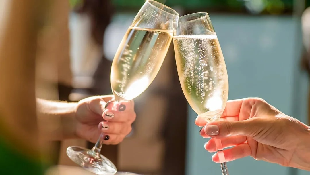 Guests toasting with champagne at Madame Tussauds Champagne Bar, London.