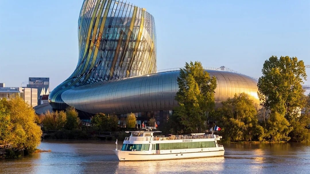Cruise boat on Bordeaux river near La Cité du Vin museum.