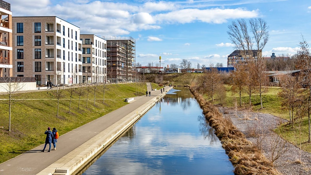 Lindenau harbor canal with modern buildings and walking path in Leipzig, Germany.