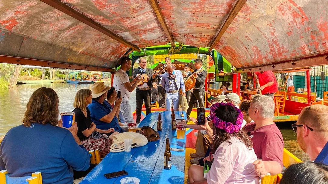 Mariachi band performing on a colorful boat during a Xochimilco tour in Mexico City.