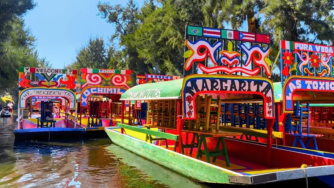 Colorful trajineras on a canal during a Xochimilco tour in Mexico City.