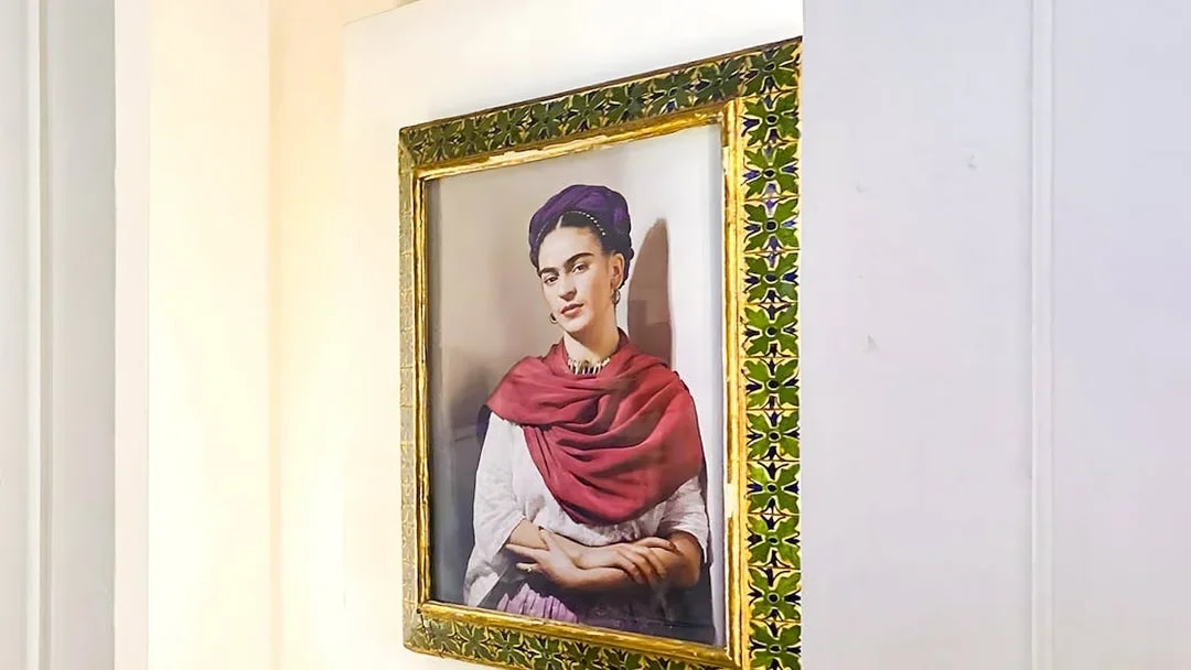 Frida Kahlo portrait in ornate frame at Frida Kahlo Museum, Mexico City.