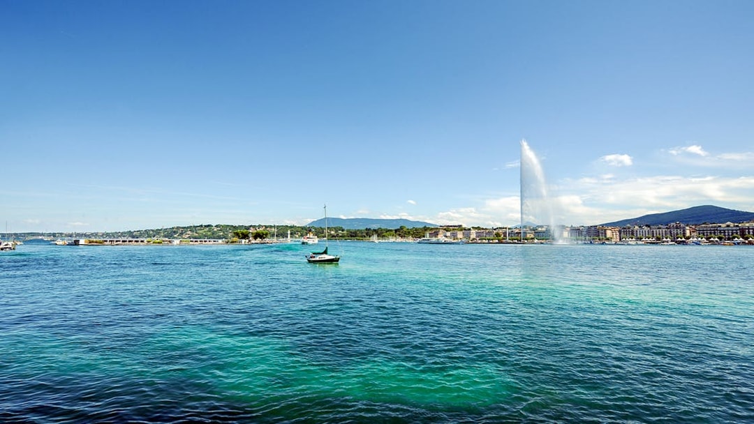 Sailboat on Lake Geneva with Jet d'Eau fountain in the background.