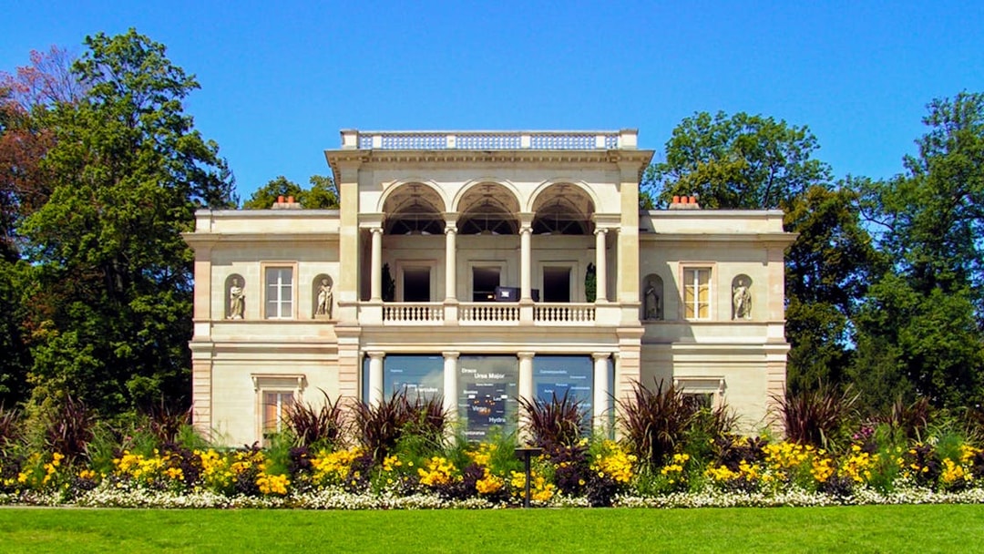 Neoclassical villa with statues and gardens in Geneva.