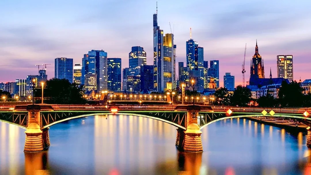 Frankfurt skyline at dusk with illuminated bridge during Evening Panorama Cruise.