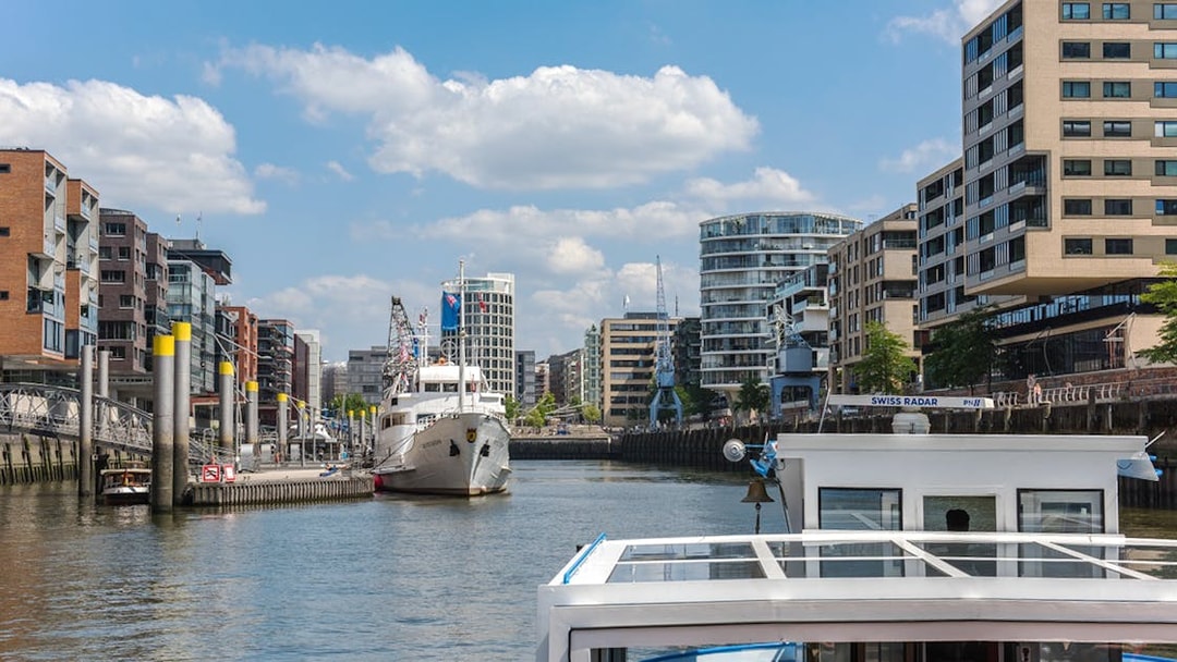 Harbor view with boats and modern buildings during Hamburg harbor cruise.