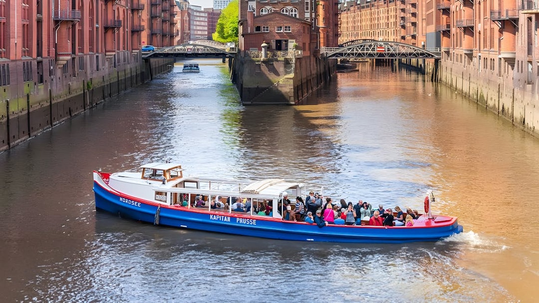 Harbor cruise boat with tourists on a canal in Hamburg's Speicherstadt district.