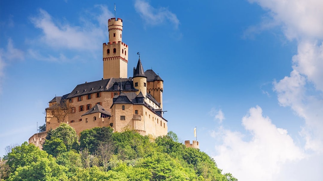 Marksburg Castle on a hilltop under a blue sky, Koblenz river cruise.